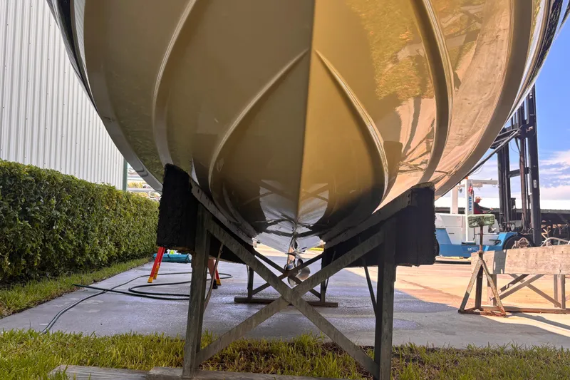 Slide: The Image of 2010 Monterey 254FS boat hull on support stands, outdoor storage area. - 4