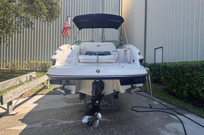 Slide: The Image of 2010 Monterey 254FS boat with American flag, parked near a building. - 8
