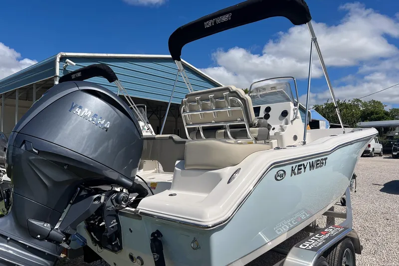 Slide: The Image of 2026 Key West 203 FS boat with Yamaha engine, parked outdoors under blue sky. - 1