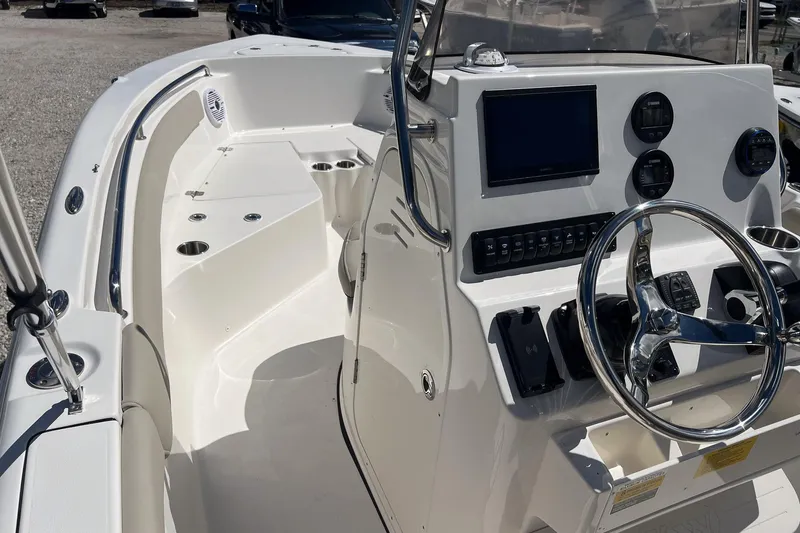 Slide: The Image of 2026 Key West 203 FS boat interior with seating, cup holders, and storage compartments. - 11