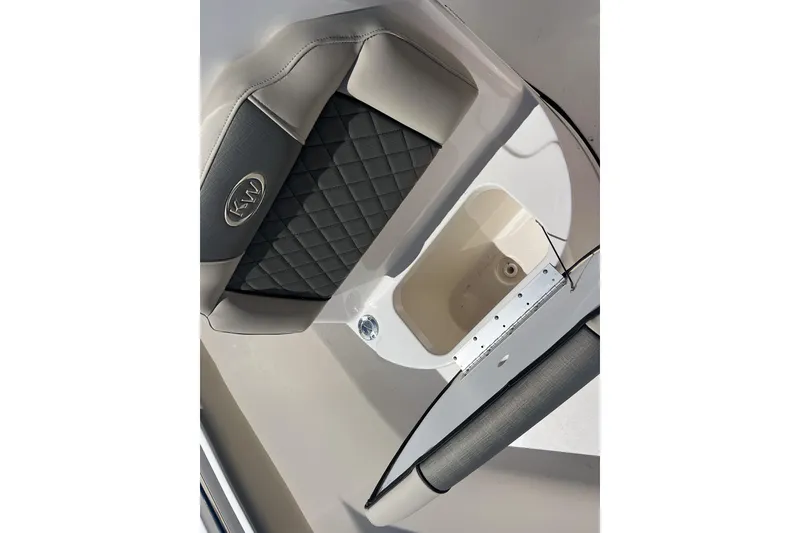 Slide: The Image of 2026 Key West 203 FS boat interior with cushioned seating and trailer in background. - 16