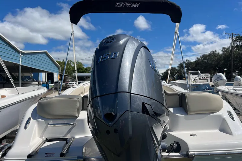 Slide: The Image of 2026 Key West 203 FS boat with Yamaha 150 engine, docked under blue sky. - 2