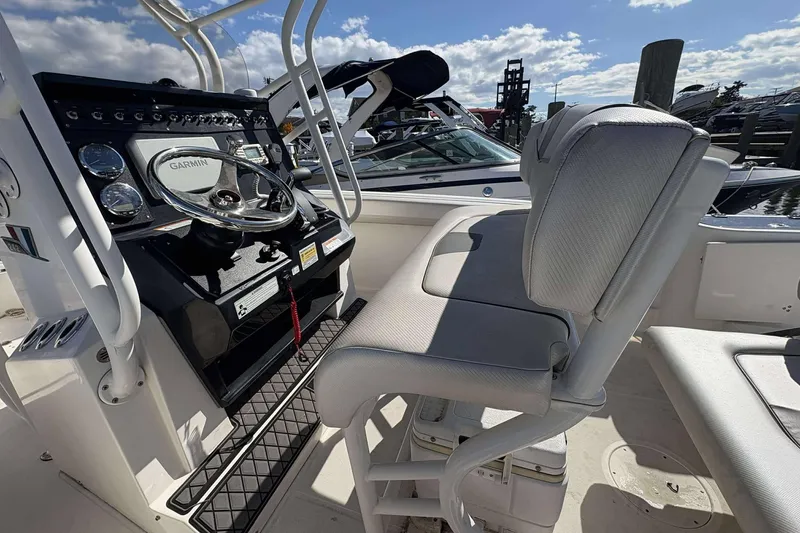 Slide: The Image of 2016 Wellcraft 242 Fisherman boat cockpit with Garmin navigation and cushioned seating. - 11