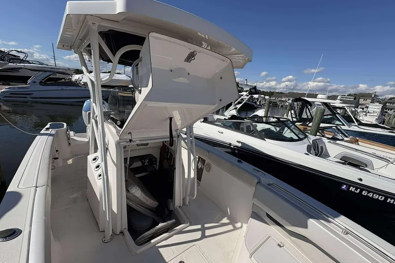 Slide: The Image of 2016 Wellcraft 242 Fisherman boat docked, showcasing open storage compartment and sleek design. - 18