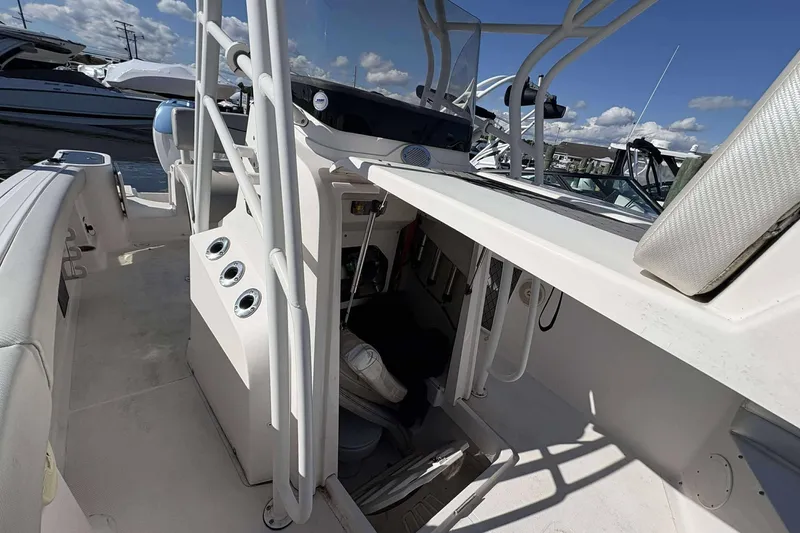 Slide: The Image of 2016 Wellcraft 242 Fisherman boat interior with seating and control panel, under a clear sky. - 19