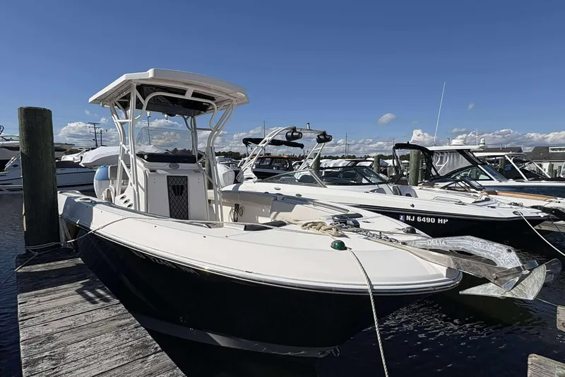 Slide: The Image of 2016 Wellcraft 242 Fisherman boat docked at marina under clear blue sky. - 2