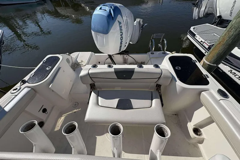 Slide: The Image of 2016 Wellcraft 242 Fisherman boat interior with motor and fishing rod holders. - 22
