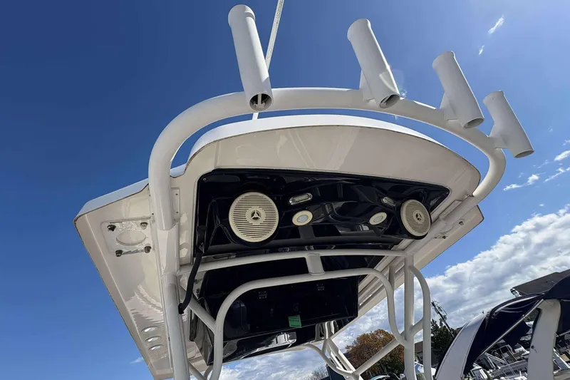 Slide: The Image of 2016 Wellcraft 242 Fisherman boat with rod holders and speakers under a clear blue sky. - 23