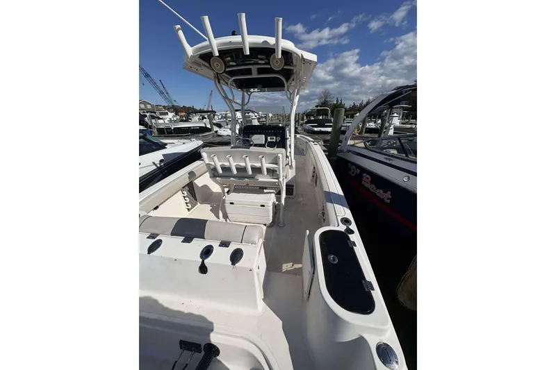 Slide: The Image of 2016 Wellcraft 242 Fisherman boat interior with seating and rod holders, docked at marina. - 8