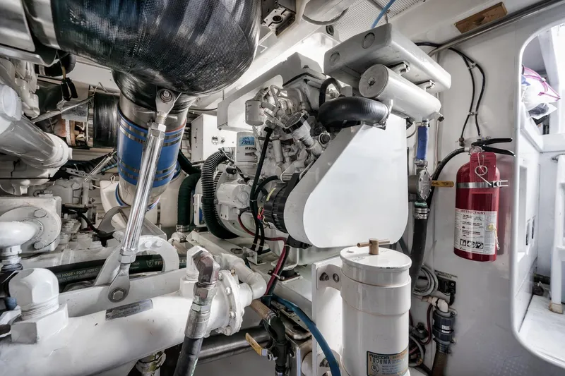 Slide: The Image of Engine room of 1993 Merritt Sportfish boat with visible machinery and fire extinguisher. - 13