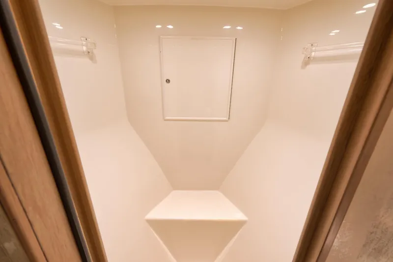 Slide: The Image of 1993 Merritt Sportfish interior storage compartment with white walls and wooden trim. - 25