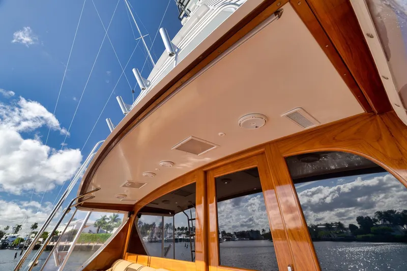 Slide: The Image of 1993 Merritt Sportfish yacht with wooden accents, under a clear blue sky. - 27