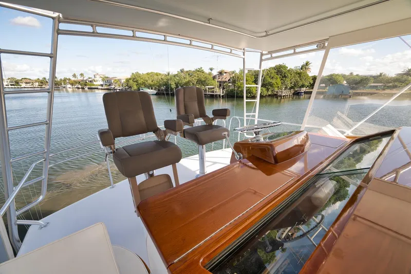 Slide: The Image of 1993 Merritt Sportfish yacht helm with dual captain chairs overlooking serene waterfront. - 48