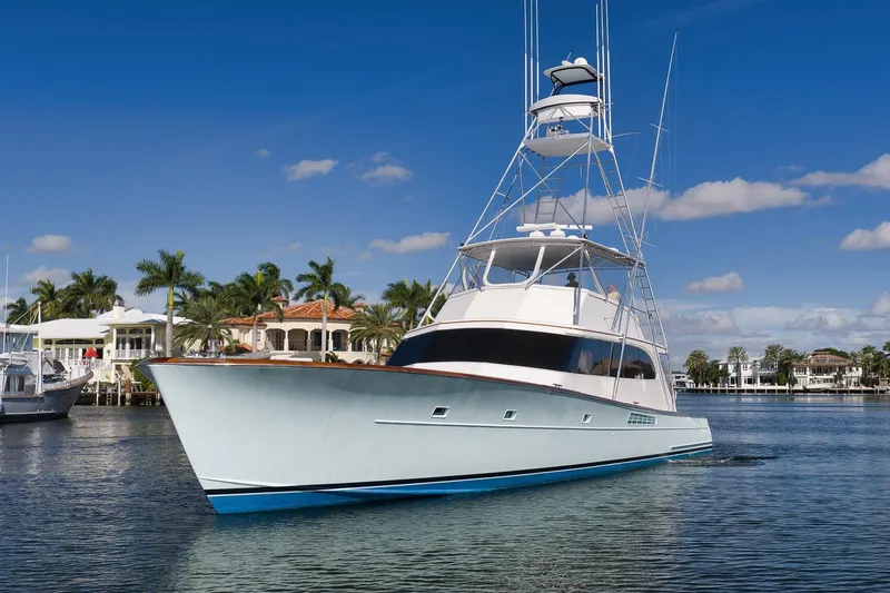 Slide: The Image of 1993 Merritt Sportfish yacht cruising on a sunny day with palm trees in the background. - 8