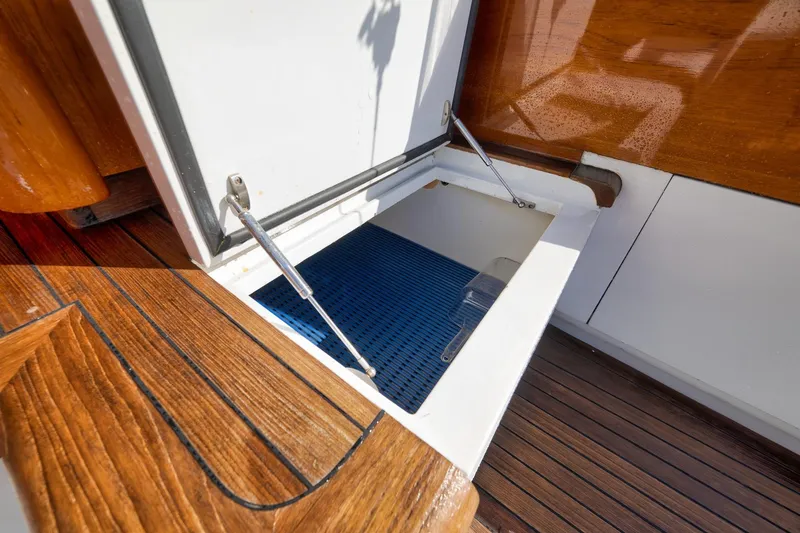 Slide: The Image of Open storage compartment on 1993 Merritt Sportfish boat with wooden deck. - 26