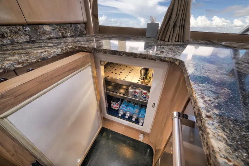 Slide: The Image of Luxurious 1993 Merritt Sportfish yacht interior with open mini fridge and granite countertop. - 31