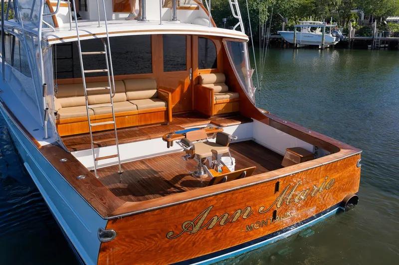 Slide: The Image of 1993 Merritt Sportfish boat with wooden deck and seating, docked on calm water. - 9