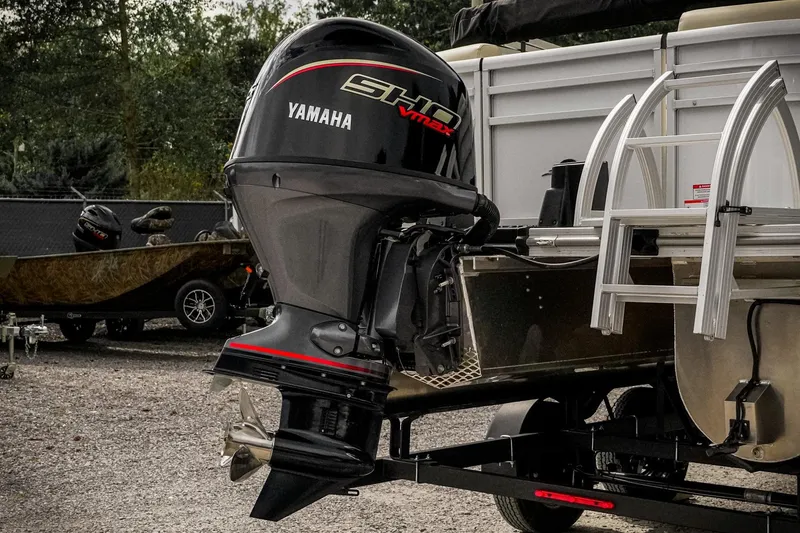 Slide: The Image of 2026 SunCatcher Select 22RC with Yamaha outboard motor, parked outdoors. - 10