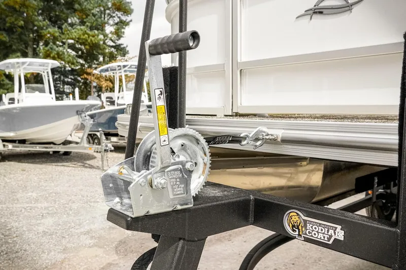 Slide: The Image of 2026 SunCatcher Select 22RC boat trailer with winch, parked outdoors. - 13