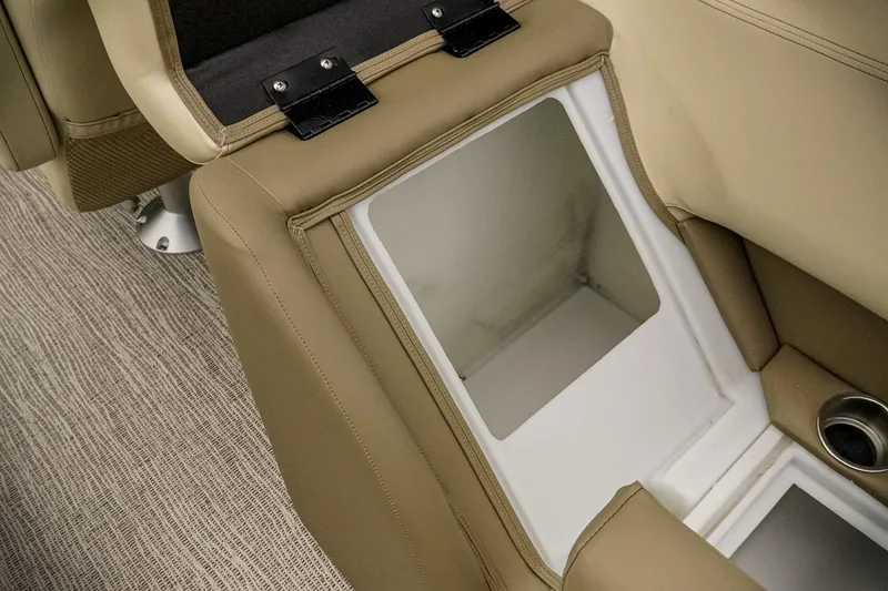 Slide: The Image of 2026 SunCatcher Select 22RC boat interior storage compartment with beige seating and cup holder. - 32