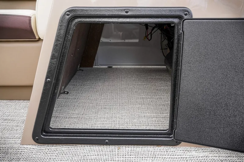 Slide: The Image of Open storage compartment in 2026 SunCatcher Select 22RC boat, featuring carpeted interior. - 43