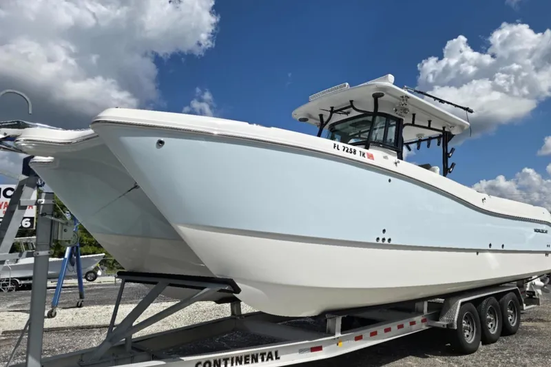Slide: The Image of 2023 World Cat 325 CC boat on trailer under blue sky. - 16