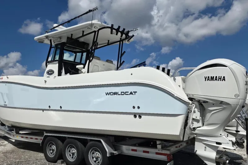Slide: The Image of 2023 World Cat 325 CC boat with Yamaha engines on a trailer under a blue sky. - 21