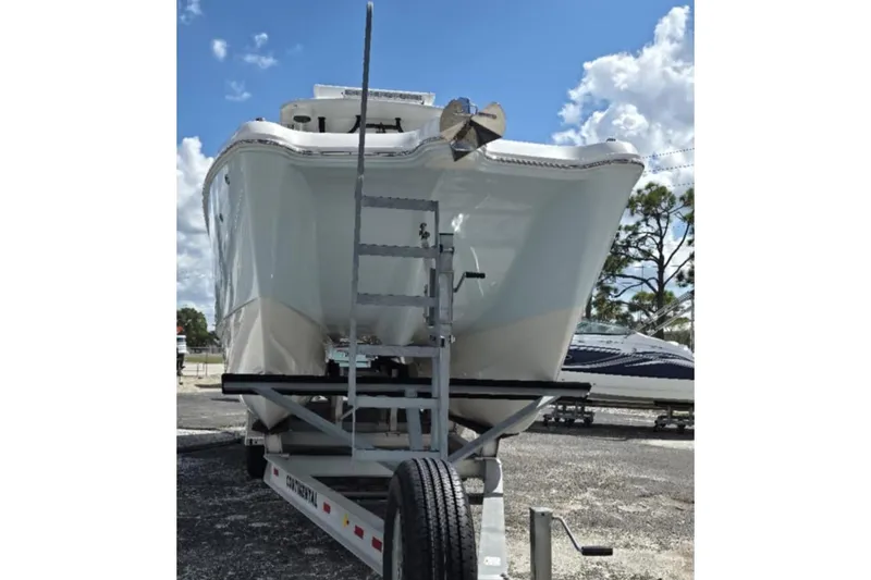 Slide: The Image of 2023 World Cat 325 CC boat on trailer, front view, under a partly cloudy sky. - 22
