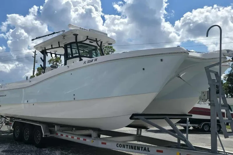Slide: The Image of 2023 World Cat 325 CC boat on trailer under cloudy sky. - 26