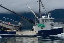 Slide: The Image of Custom Longliner 58 fishing boat from 1979 on calm waters with mountainous backdrop. - 4