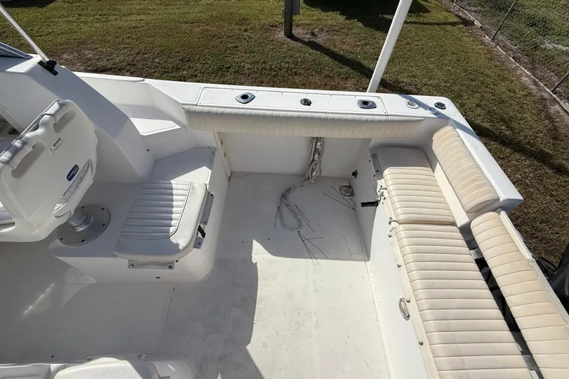 Slide: The Image of 2005 Mako 215 Walk Around boat interior with seating and fishing rod holders. - 10