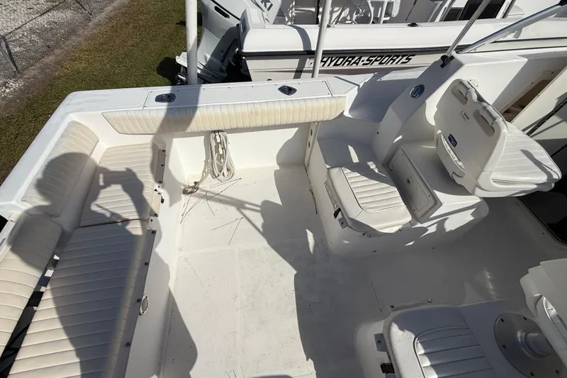 Slide: The Image of 2005 Mako 215 Walk Around boat interior with white seating and storage compartments. - 11