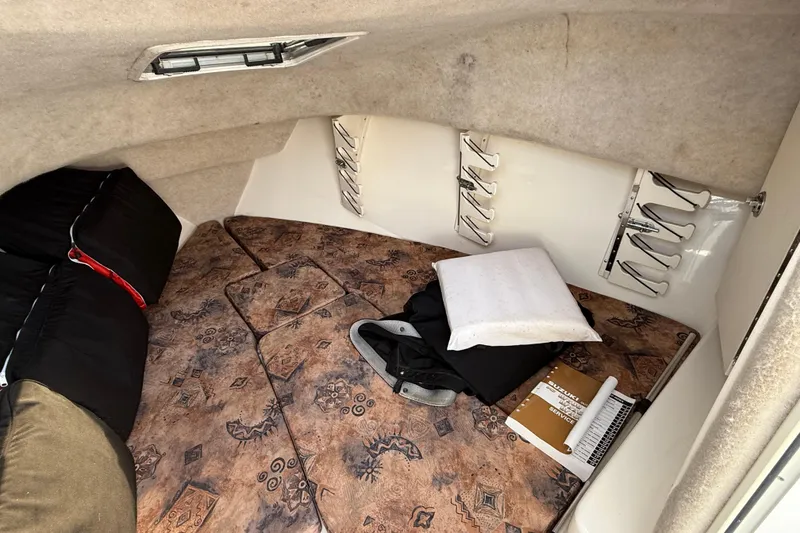 Slide: The Image of Cozy cabin interior of 2005 Mako 215 Walk Around boat with cushions and storage. - 16
