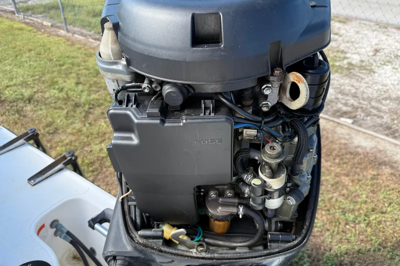 Slide: The Image of Close-up of a 2005 Mako 215 Walk Around boat engine, showcasing detailed components. - 7