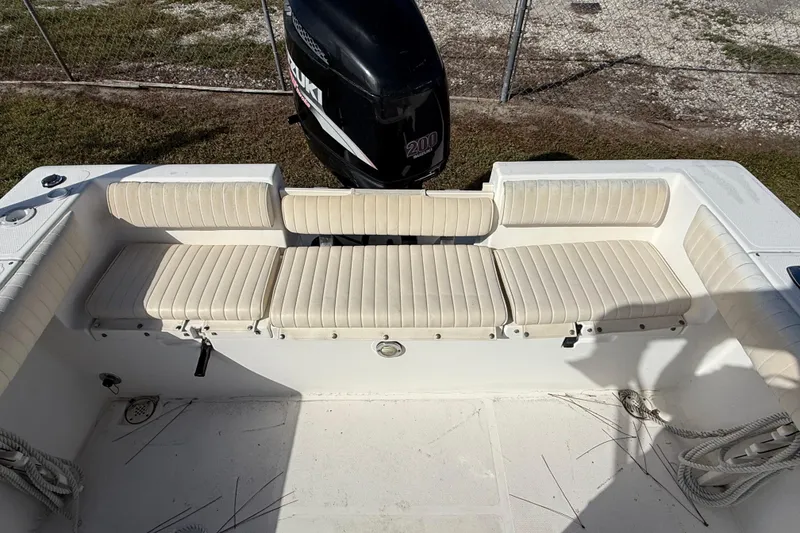 Slide: The Image of 2005 Mako 215 Walk Around boat interior with cushioned seating and Suzuki outboard motor. - 9