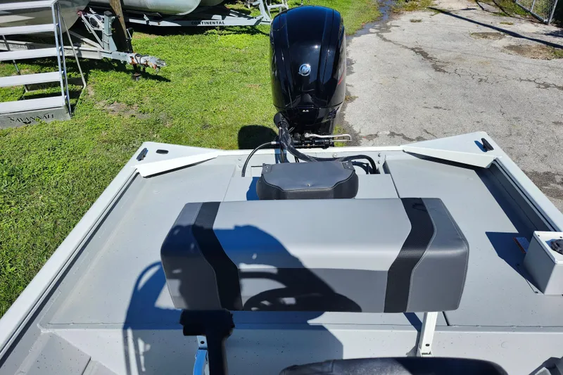 Slide: The Image of 2026 Lowe Roughneck 1860CC boat with outboard motor, parked on grass. - 10