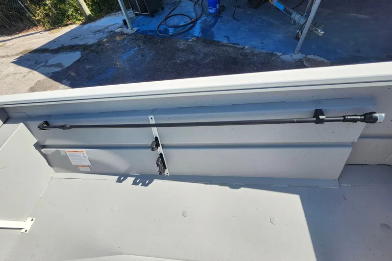 Slide: The Image of 2026 Lowe Roughneck 1860CC boat interior with rod holder and storage compartment. - 19