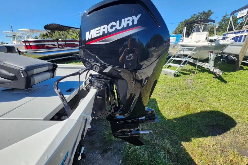 Slide: The Image of 2026 Lowe Roughneck 1860CC with Mercury outboard motor, parked on grass. - 20