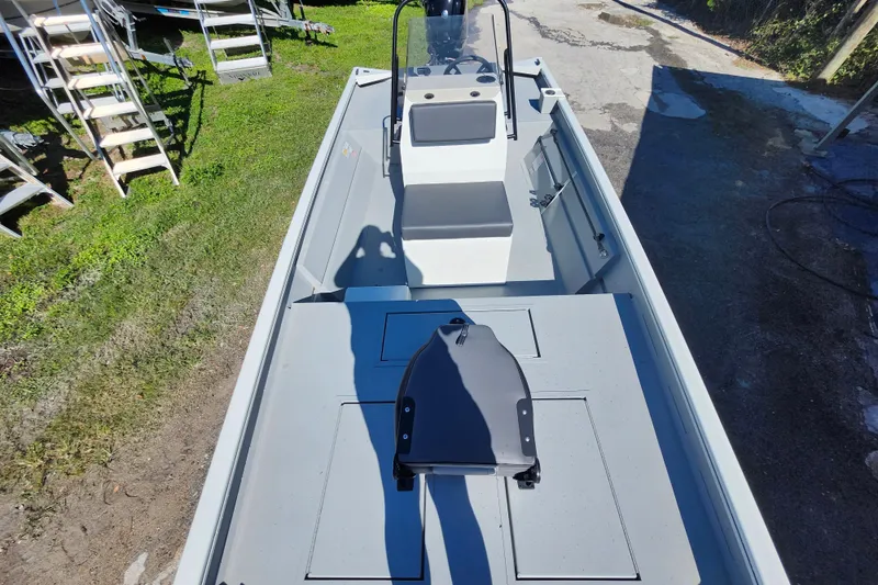 Slide: The Image of 2026 Lowe Roughneck 1860CC boat, interior view, parked on grass and pavement. - 24