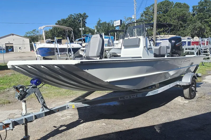 Slide: The Image of 2026 Lowe Roughneck 1860CC boat on trailer, parked outdoors under clear sky. - 3