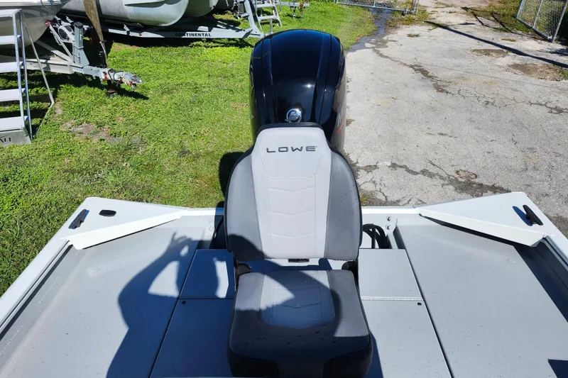 Slide: The Image of 2026 Lowe Roughneck 1860CC boat seat and motor, parked on grass. - 8