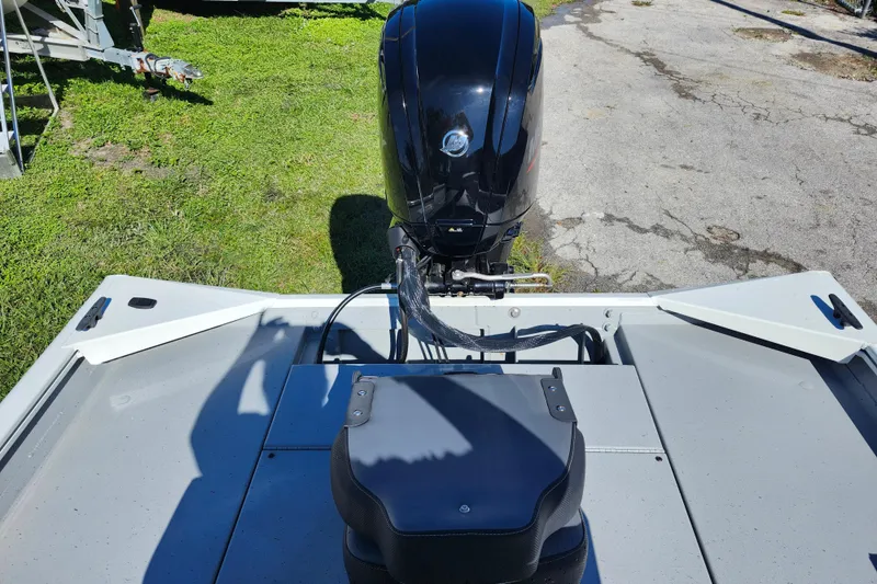 Slide: The Image of 2026 Lowe Roughneck 1860CC boat with outboard motor, parked on grass and pavement. - 9