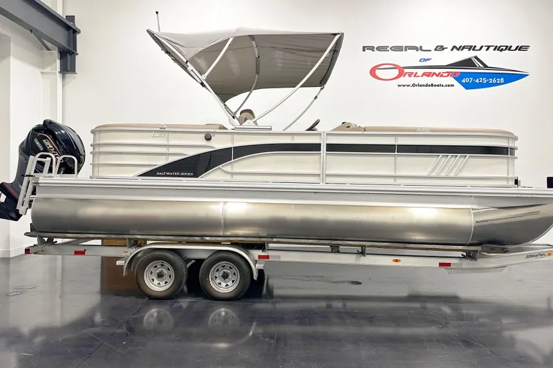 The Image of 2025 Bennington 23LPDSR pontoon boat on trailer in showroom. - 1