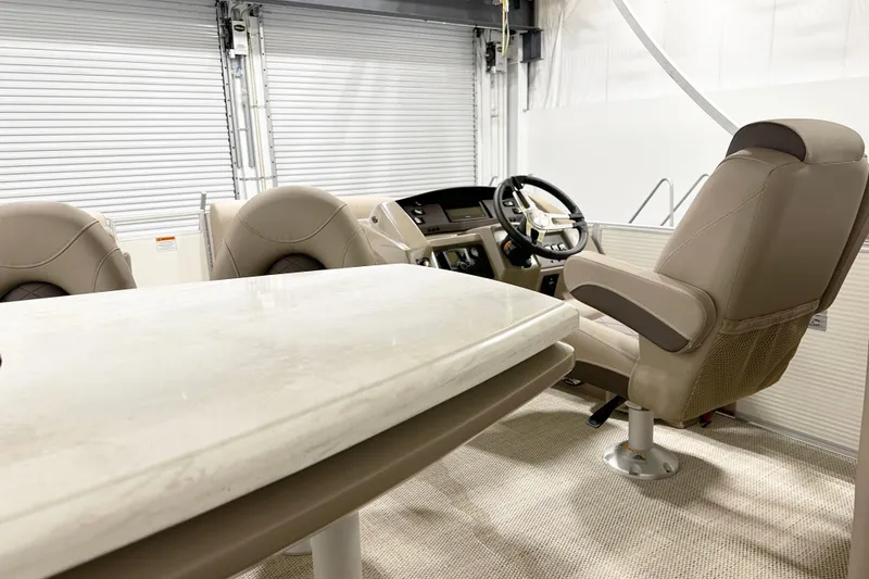 Slide: The Image of Interior of 2025 Bennington 23LPDSR boat with beige seating and steering console. - 9