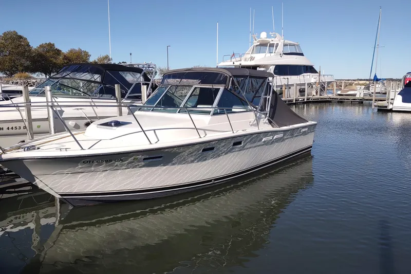The Image of 1992 Tiara Yachts 2700 Open docked in a marina under clear skies. - 1