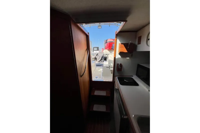 Slide: The Image of Interior view of 1992 Tiara Yachts 2700 Open, featuring compact kitchen area. - 13