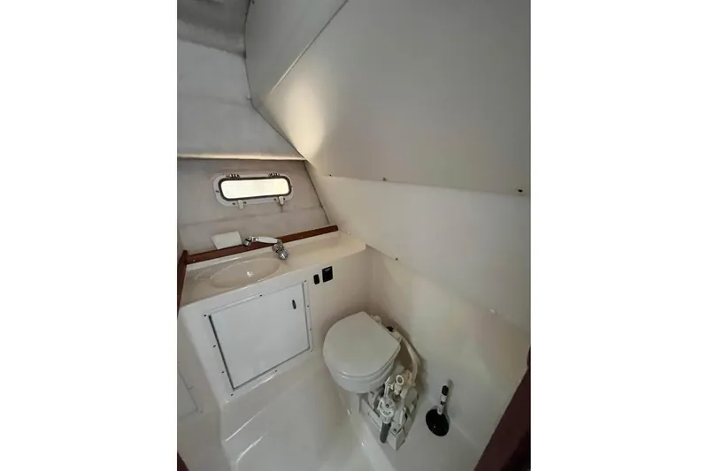 Slide: The Image of 1992 Tiara Yachts 2700 Open bathroom interior with sink, toilet, and porthole window. - 14