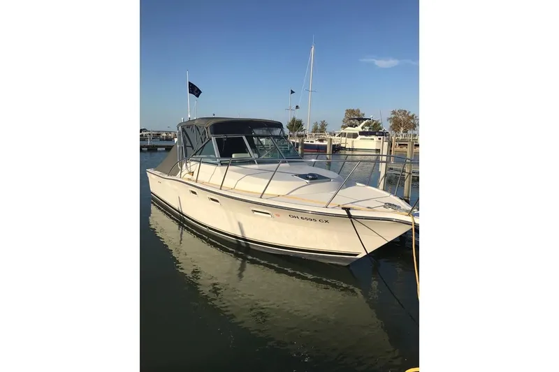 Slide: The Image of 1992 Tiara Yachts 2700 Open boat docked in a marina under clear skies. - 4