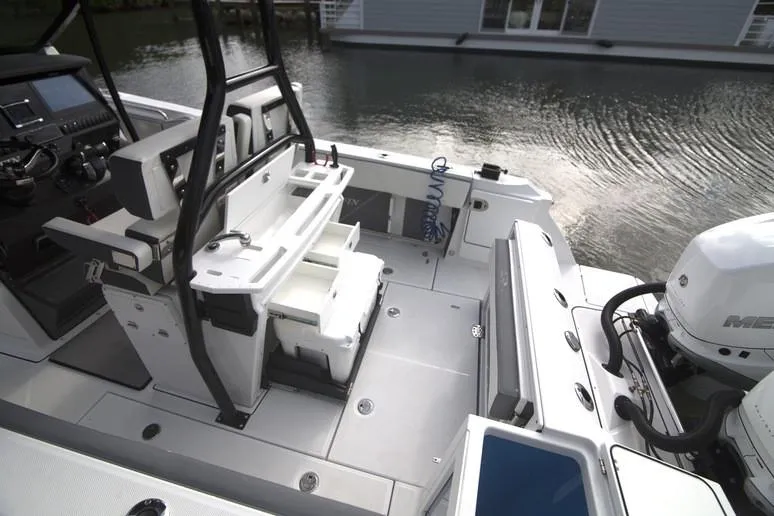 Slide: The Image of 2020 Blackfin 272 CC boat on water, surrounded by palm trees and cloudy sky. - 14