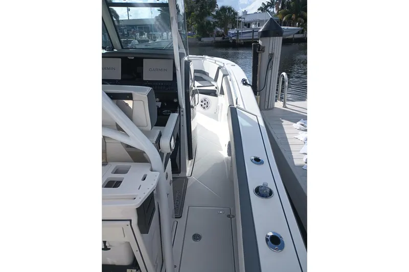 Slide: The Image of 2020 Blackfin 272 CC boat interior with Garmin displays, docked by the water. - 20
